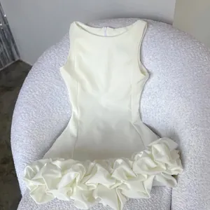 Detailed macro view of white Hepburn style sleeveless dress featuring 3D ruffled hem