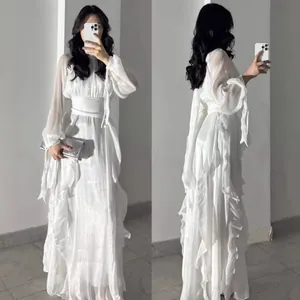 Elegant white long-sleeved satin maxi dress with ruffled detailing and cinched waist.