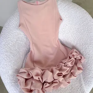 Macro detail of the elegant ruffled hem on a pink sleeveless Hepburn style mini cocktail dress