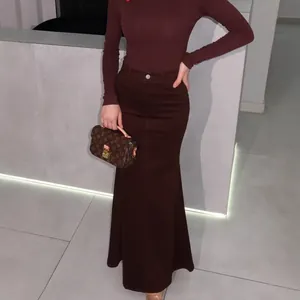 Close-up of a maroon high-waisted fishtail skirt showing fabric texture and elegant fit