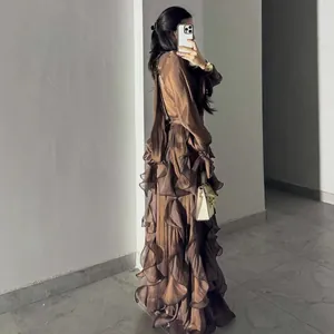 Side view of chocolate brown satin evening gown with tiered ruffles and pleats