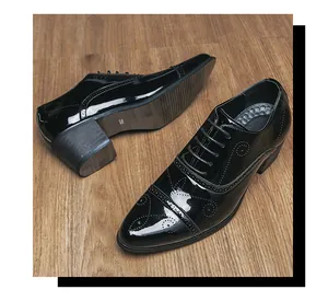 Detailed view of black patent leather men's pointed-toe high heel shoes with brogue pattern