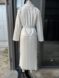Vista trasera de un elegante conjunto de blazer blanco y falda plisada en un maniquí