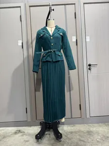 Vista completa de un conjunto de chaqueta verde oscuro y falda plisada en un maniquí