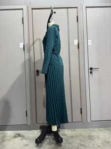 Vista lateral detallada de un elegante conjunto de falda plisada verde oscuro y blazer con botones