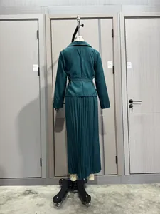 Vista trasera de un elegante conjunto de dos piezas verde oscuro con blazer y falda plisada.