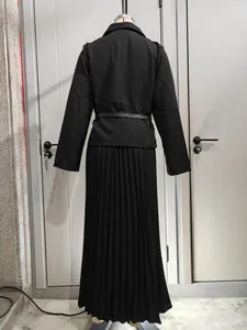 Vista trasera de elegante blazer negro con cinturón y falda larga plisada en maniquí