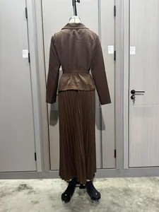 Vista trasera detallada de conjunto de chaqueta marrón y falda larga plisada en maniquí