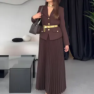 Vista detallada del elegante conjunto de chaqueta marrón y falda plisada para el otoño