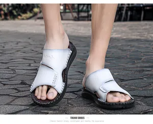 Gros plan de sandales en cuir blanc pour hommes avec coutures et semelles souples.