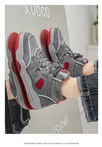 Vista dettagliata di sneaker alte grigie e rosse con suola spessa e riflesso.