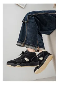 Dettaglio laterale di sneakers nere alte con suola spessa e jeans in denim scuro