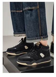 Dettaglio di sneaker alte nere da uomo in pelle scamosciata con jeans risvoltati.