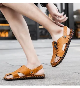 Dettaglio di eleganti sandali da uomo in pelle marrone con cinturino sul tallone regolabile