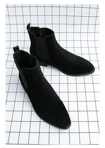 Close-up detail of black suede pointed toe Chelsea boots for men in British style.
