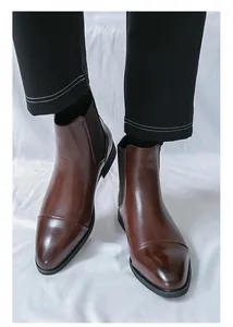 Close-up view of elegant brown pointed-toe Chelsea boots for men in classic British style