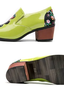 Detailed view of lime green patent leather shoe with floral print and rubber sole