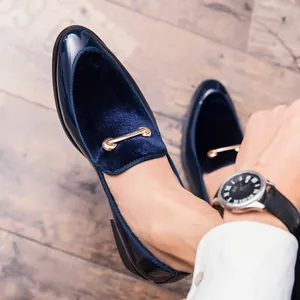 Vista dettagliata di mocassini in velluto blu navy e vernice con fibbia in metallo dorato.