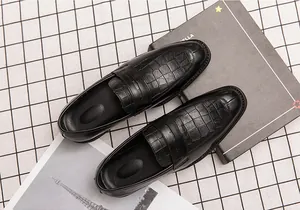 Gedetailleerd bovenaanzicht van zwarte herenloafers met krokodillenprint voor zakelijk