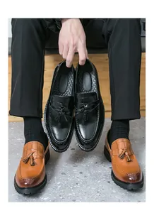 Detail shot of men's retro tassel loafers with embossed crocodile pattern and thick soles.