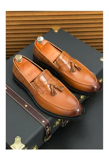 Detailed view of men's brown tassel loafers with embossed crocodile pattern