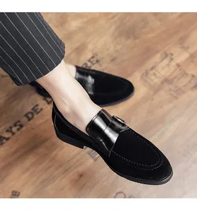 Close-up of black suede loafers with patent leather strap and metal buckle detail