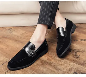Macro detail of men's black suede and patent leather loafers with metal buckle