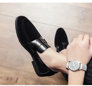 Close-up detail of black suede loafers with smooth leather strap across the vamp.