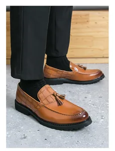 Stylish brown tassel loafers for men featuring crocodile skin texture and durable black lug soles