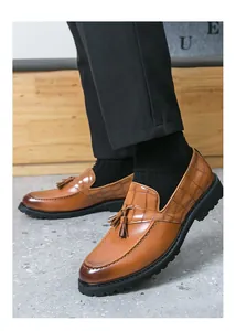 Detailed side view of men's brown vintage tassel loafers featuring crocodile texture accents