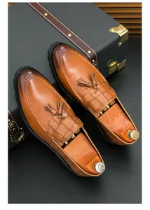 Detailed view of men's brown leather loafers featuring tassels and crocodile texture finish