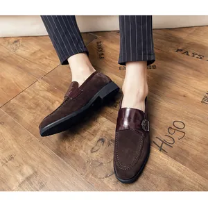Close-up of men's retro brown suede loafers with stylish buckle detail and pinstripe pants.
