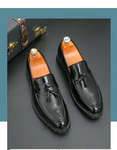 Detail showing black retro tassel loafers with elegant crocodile texture on the upper