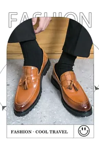 Detail shot of classic brown leather tassel loafers for men with crocodile texture