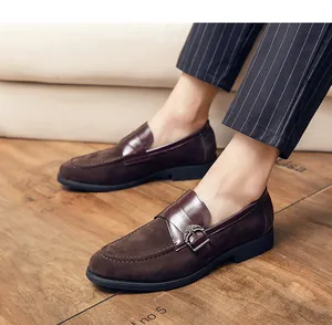 Close-up view of men's vintage brown suede loafers featuring a leather buckle strap