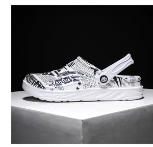 Side view of men's white breathable clogs with black graphic newspaper print.