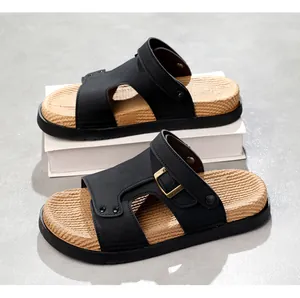 Nahaufnahme von schwarzen Herren-Sandalen mit gewebtem Fußbett und dekorativer Schnalle.