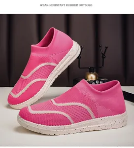 Close-up detail of pink knitted slip-on sneakers featuring a durable speckled rubber outsole