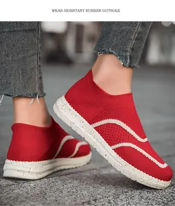 Detailed shot of stylish red knit slip-on sneakers with durable white speckled rubber soles