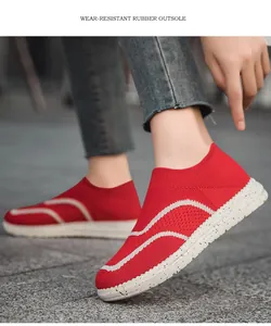 Detail showing red knit slip-on sneakers with a wear-resistant speckled rubber outsole.