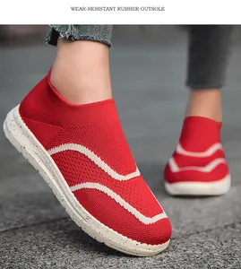 Close-up of red mesh slip-on sneakers with white wavy details and rubber outsole