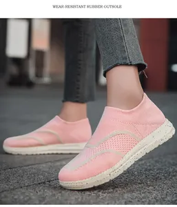 Detail shot of pink knit slip-on sneakers showing wear-resistant rubber outsole design.