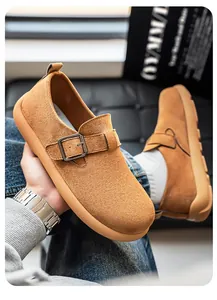 Detailaufnahme brauner Wildleder-Slipper für Herren mit stilvollem Metallschnallenriemen.