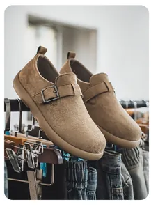 Detailansicht von braunen Wildleder-Slippern mit Metallschnalle auf einem Kleiderständer