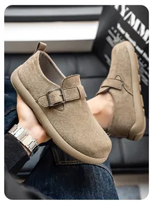 Nahaufnahme brauner Wildleder-Loafer mit Metallschnalle und Slipper-Design