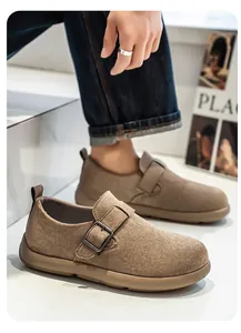 Nahaufnahme von braunen Herren-Wildleder-Slippern mit Schnalle und weicher Textur