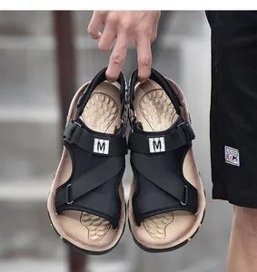 Nahaufnahme von schwarzen atmungsaktiven Herren-Outdoor-Sportsandalen, die gehalten werden