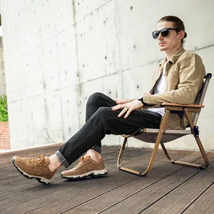 Dettaglio delle scarpe da trekking in pelle beige indossate da un modello all'aperto