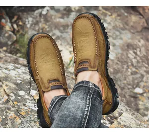 Primer plano de zapatos de senderismo de cuero marrón para hombre en un terreno rocoso