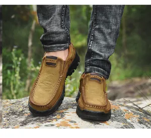 Primer plano de zapatos de senderismo de cuero marrón para hombre en suelo boscoso